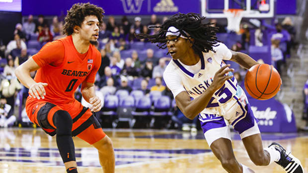 Washington Huskies guard Keyon Menifield dribbles against Oregon State Beavers guard Jordan Pope during the first half at Alaska Airlines Arena.